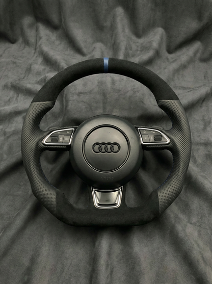 Black Audi steering wheel on a gray fabric background